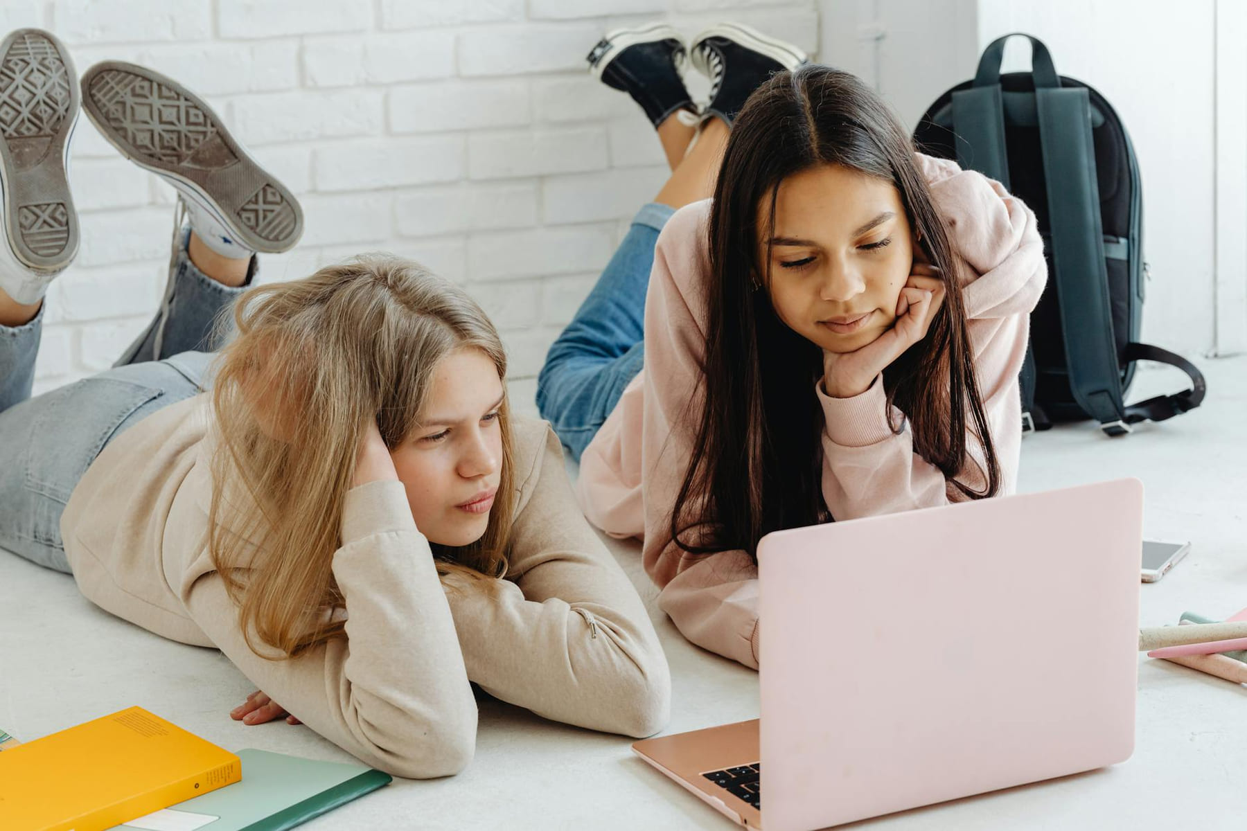 Two teenage girls studying together using a laptop indoors, emphasizing friendship and education. on Skill Forge