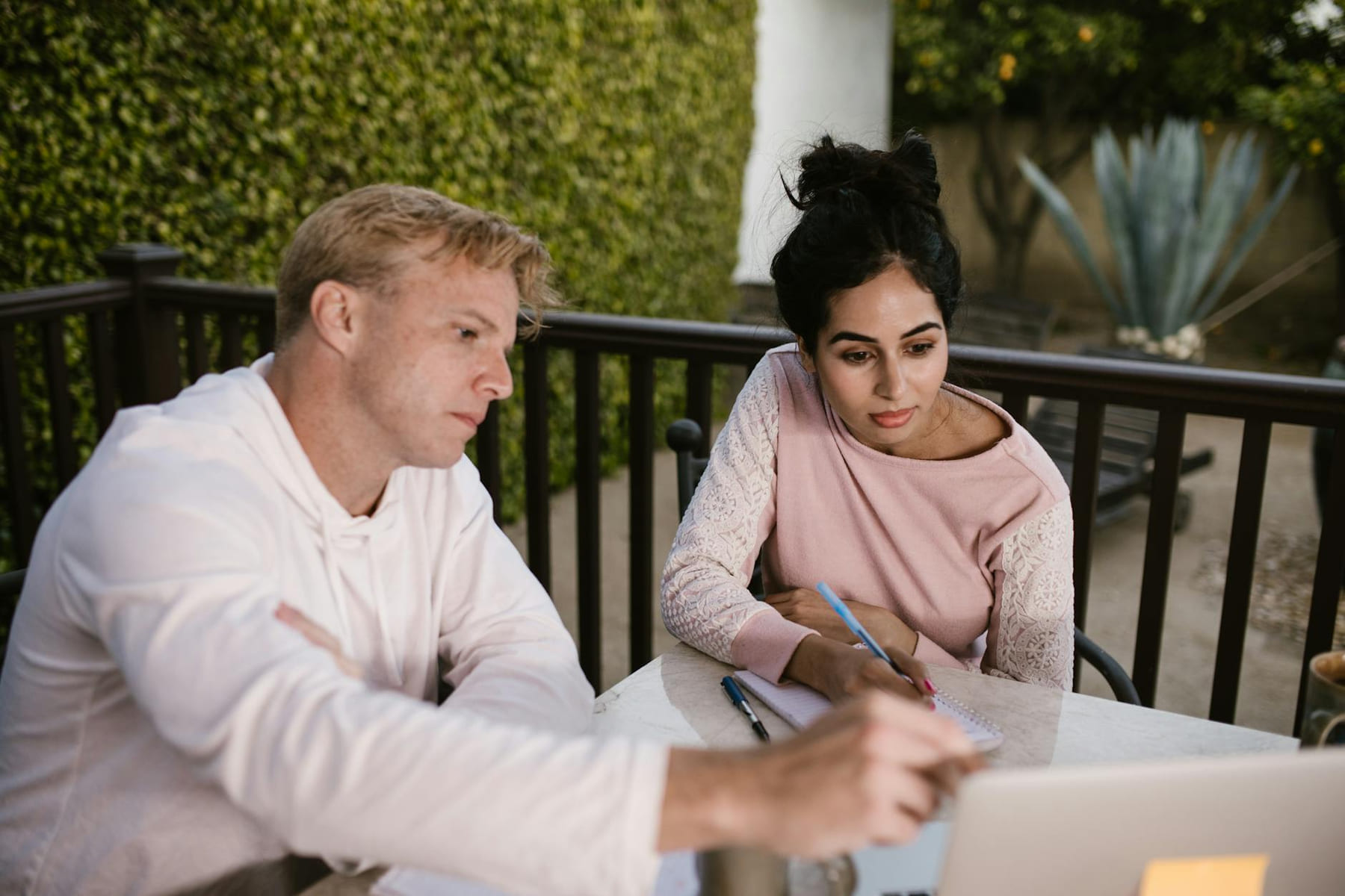 A man and woman engaged in online learning outdoors, collaborating on a laptop. on Skill Forge