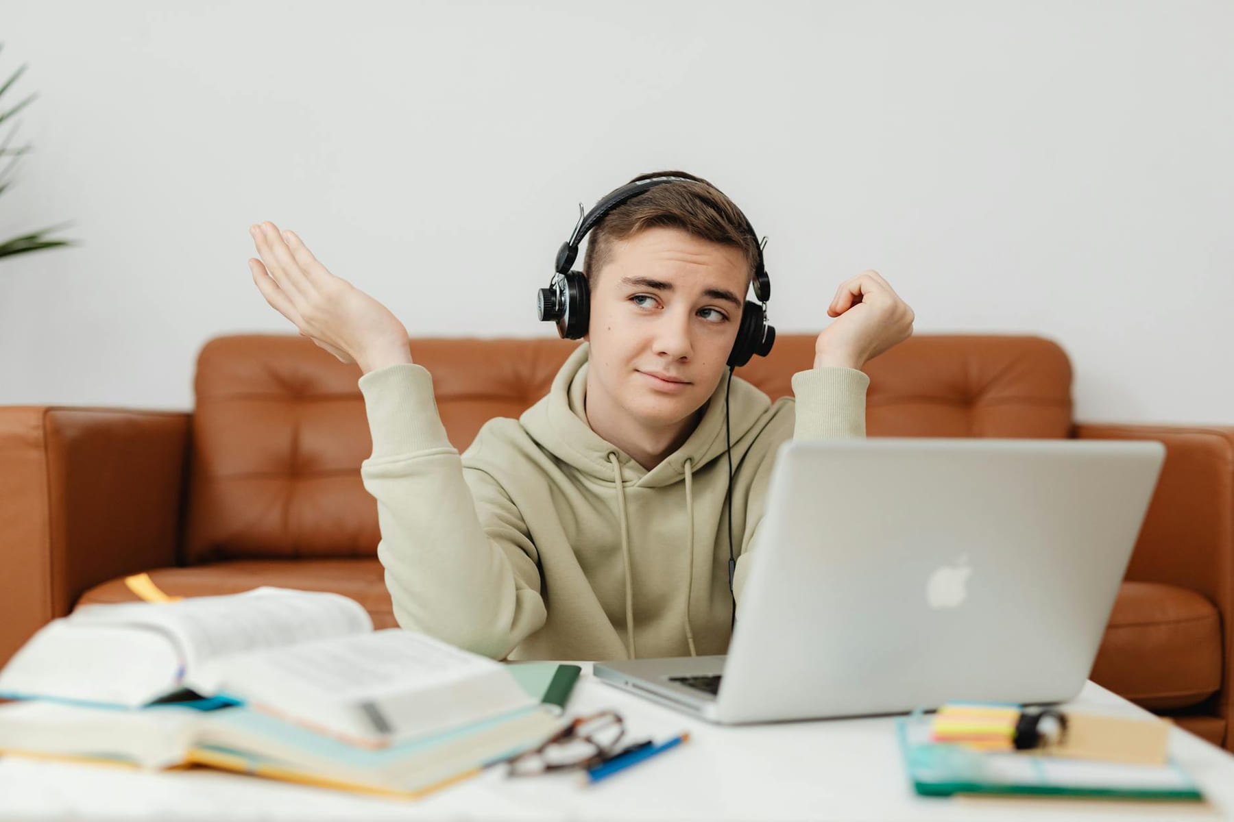 Young man in hoodie using laptop and headphones for online learning at home. on Skill Forge