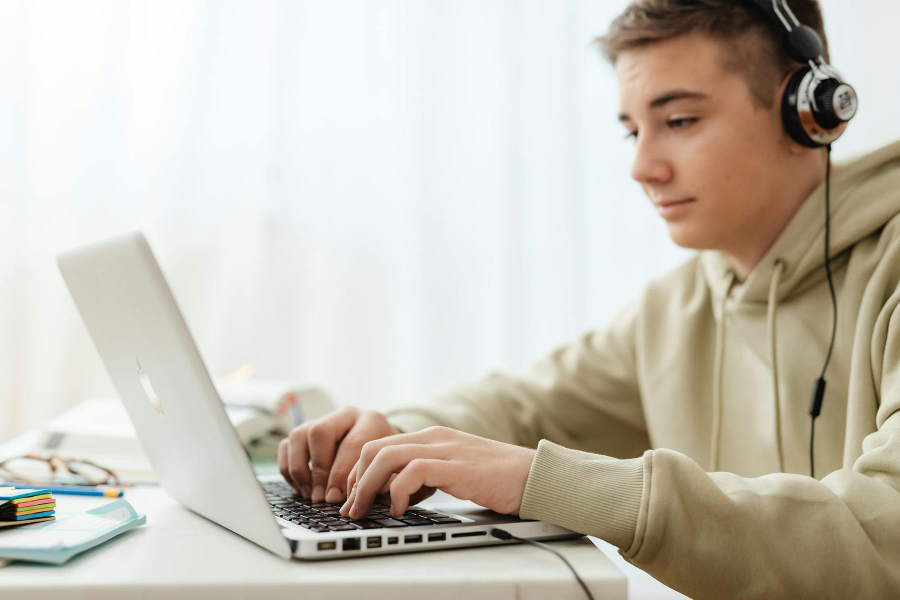 Teen using a laptop and headphones for online learning at home. on Skill Forge