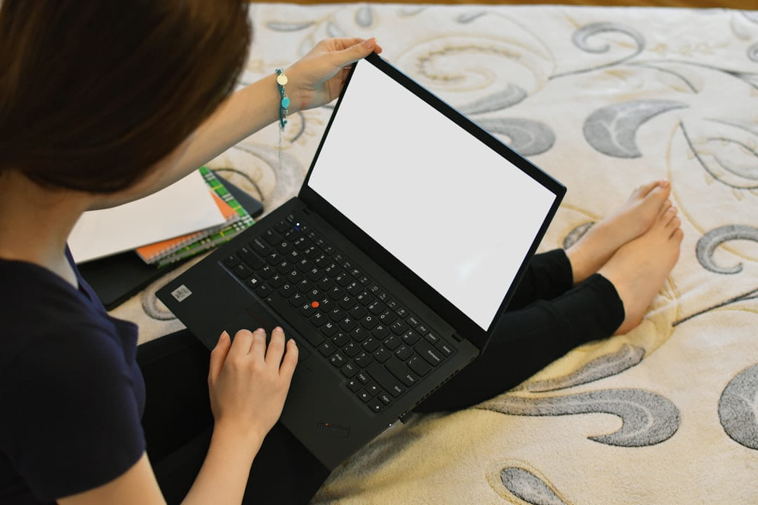 a woman sitting on a bed using a laptop computer on Skill Forge