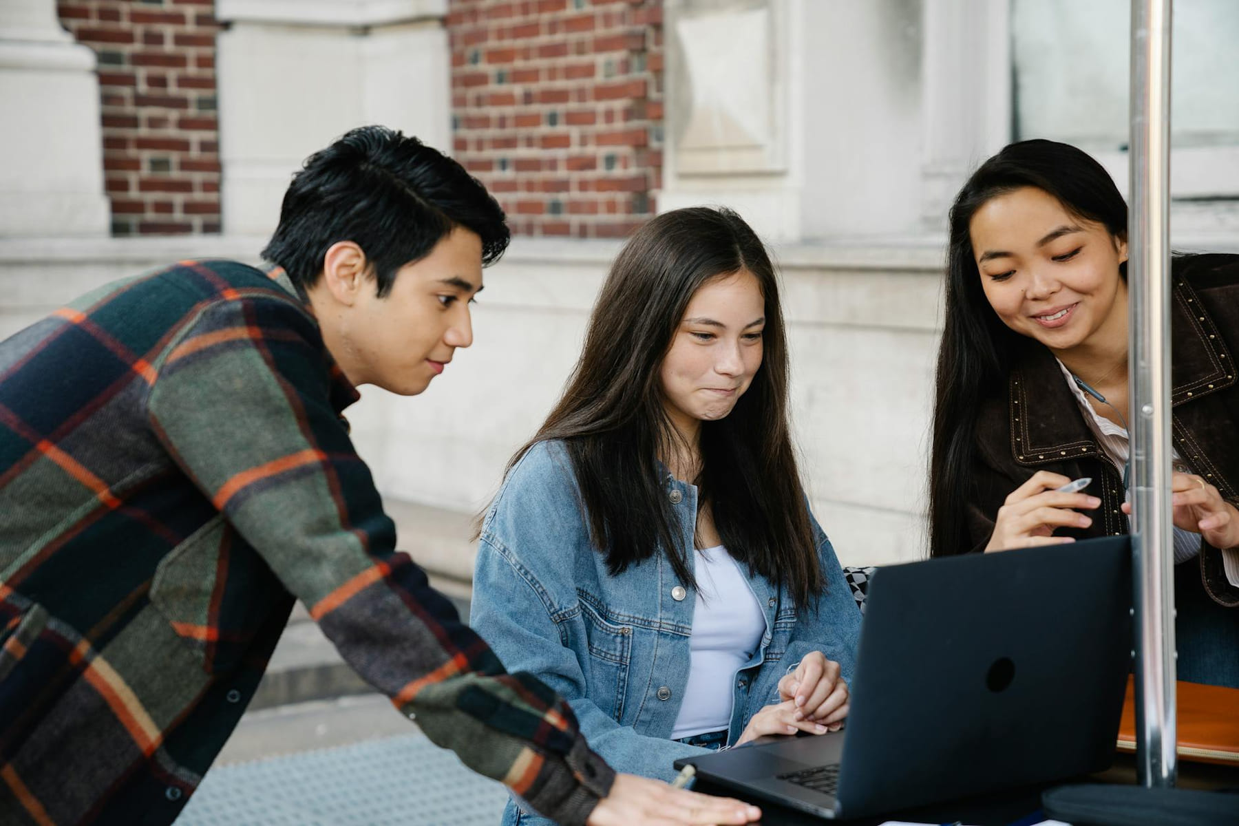 Diverse group of college students studying outdoors with a laptop, fostering collaboration. on Skill Forge