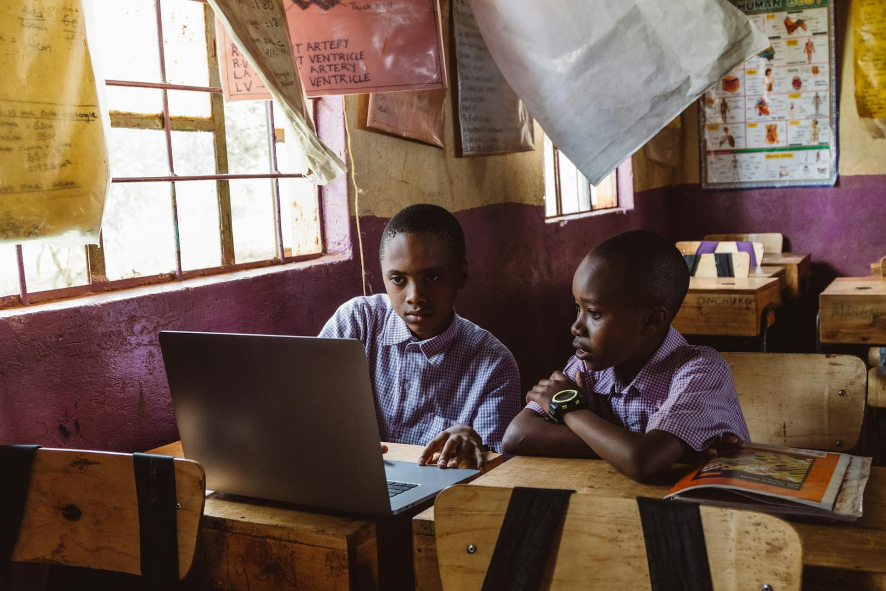 Two boys in a classroom using a laptop for studying, fostering learning and teamwork. on Skill Forge