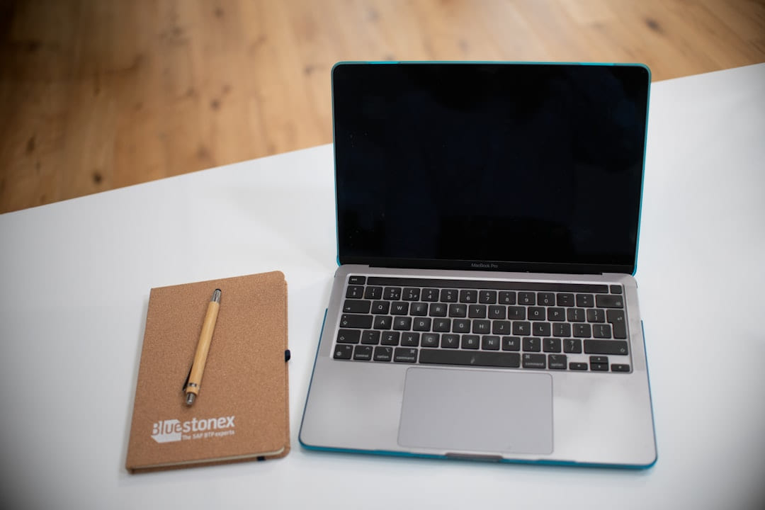 Laptop and notebook with pen on a desk on Skill Forge
