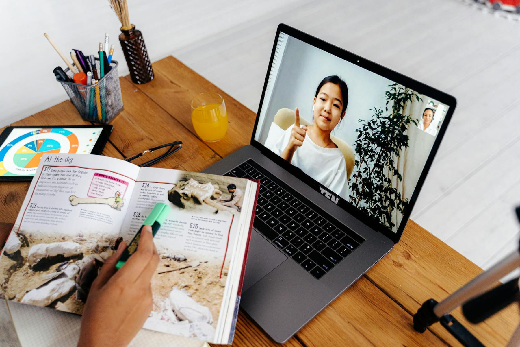 Online teaching session with digital tools, featuring a woman on a laptop screen and educational materials. on Skill Forge