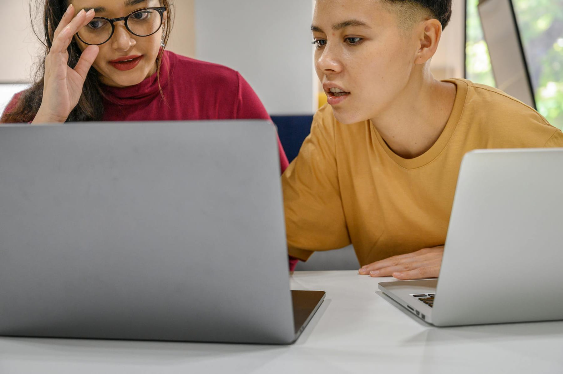 Two people collaborating intensely over laptops, working on a project indoors. on Skill Forge